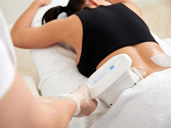 person receiving a back treatment with a medical device for muscle pain relief relaxation therapy