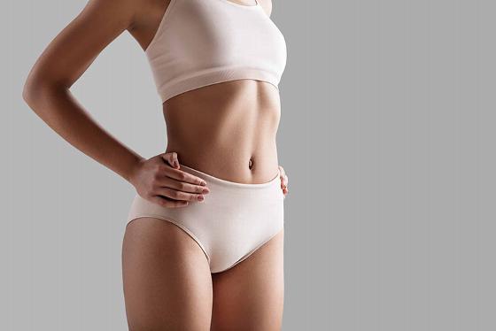 woman in neutral colored undergarments demonstrating a confident posture showcasing a toned midsection promoting healthy lifestyle choices and fitness 4 ways to improve wellness